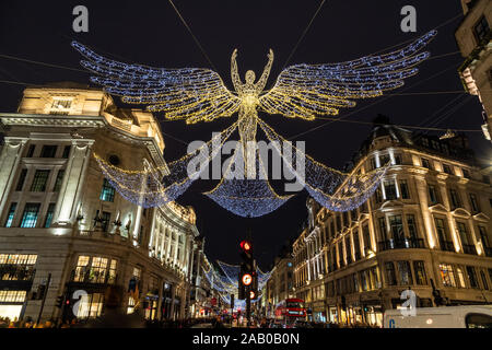 LONDON, Großbritannien - 24. Nov. 2019: Regent Street in London während der Weihnachtsferien mit den Lichtern und Dekorationen. Man kann auf der Straße gesehen werden. Stockfoto