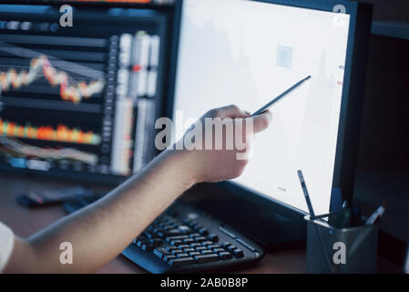 Die Analyse der Daten. Nahaufnahme der junge Unternehmer, der auf die Daten in der Tabelle mit Pen präsentiert, während in der kreativen Arbeiten im Büro Stockfoto