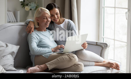 Mutter und erwachsene Tochter ruht auf dem Tisch mit Computer Stockfoto