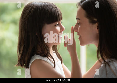 Kleine Tochter Berühren der Nase des liebevollen Mami Liebe Stockfoto