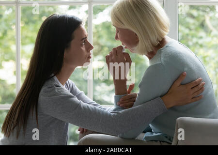 Erwachsene erwachsene Tochter 60 Jahre älteren Mutter beruhigen Stockfoto