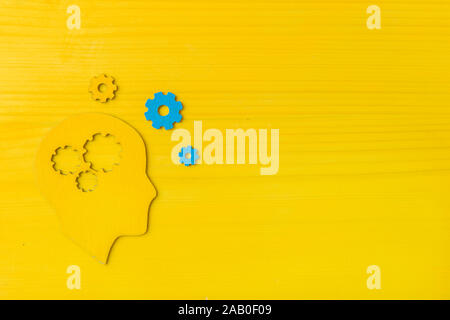 Gehirn arbeitet Konzept. Denken, Kreativität Konzept des menschlichen Kopfes mit Zahnrädern auf gelbem Hintergrund Stockfoto