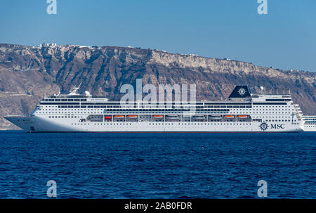 Fira, Griechenland - 16. Juli 2019: Die Schweizerische Kreuzfahrtschiff MSC Sinfonia in der Ägäis verankert an der Küste von Santorini in der Nähe der Fira Stockfoto