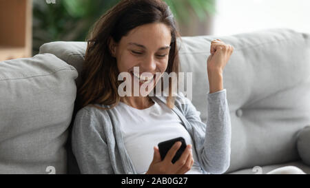 Glückliche Frau hält Smartphone erhielt lang erwartete Nachricht Stockfoto