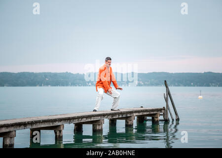 Ein Mann, der am fruehen Morgen Qi-Gong-Uebungen am Starnberger See durchfuehrt Stockfoto