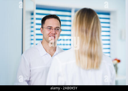 Arzt sprechen und lachen mit seiner Amme Assistant Stockfoto
