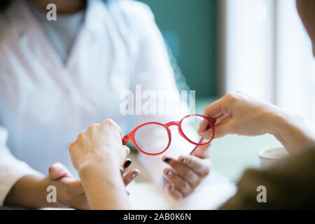 Die Hände der jungen Frau, Paar neue Brillen von denen der Kliniker Stockfoto
