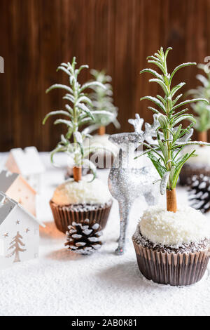 Süße Weihnachtsbaum schoko Cupcakes mit Coconut cream Topping, bestäubt mit Puderzucker Stockfoto