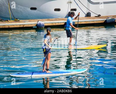 Eine junge Frau und ein Mann paddelt auf ein Stand Up Paddle Board im Santa Barbara Channel in den Hafen von Santa Barbara, CA, USA, Stockfoto