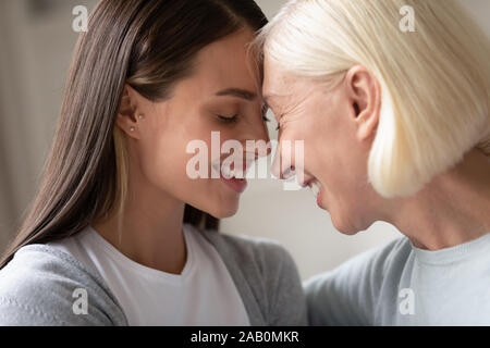 Close up Gesichter alte Mutter junge Tochter touch Stirnen Stockfoto