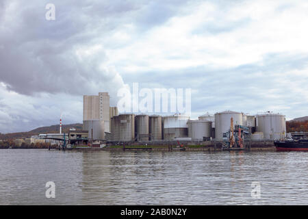 Blick auf den Rhein mit industriellen Tanks für flüssige Brennstoffe. Industrielle Gebäude am Ufer des Flusses. Wasserstraße Kraftstoff transport Schweiz Stockfoto