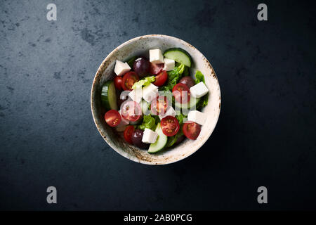 Salat mit Kalamata Oliven, Gurken Tomaten und Feta Käse auf dem schwarzen Stein. Stockfoto