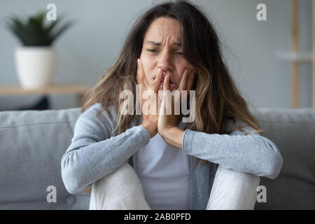 Nahaufnahme der weiblichen Sitzen auf der Couch suchen unglücklich und verzweifelt Stockfoto