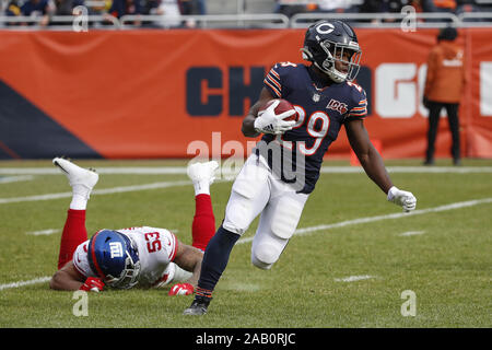 Chicago, Vereinigte Staaten. 24 Nov, 2019. Chicago Bears zurück laufen Tarik Cohen (29) läuft mit dem Ball hinter New York Giants linebacker Oshane Ximines (53) in der ersten Jahreshälfte ein NFL Spiel bei dem Soldier Field in Chicago am Sonntag, 24. November 2019. Foto von Kamil Krzaczynski/UPI Quelle: UPI/Alamy leben Nachrichten Stockfoto