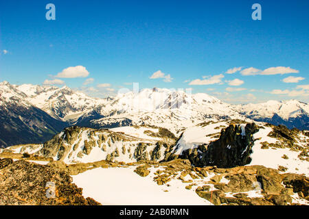 Bunte Schichten der Erdkruste, mehrschichtige Rocky Mountains. Auf den felsigen Gipfeln der Berge wachsen Bäume, Frühling in den Bergen, Berge Stockfoto