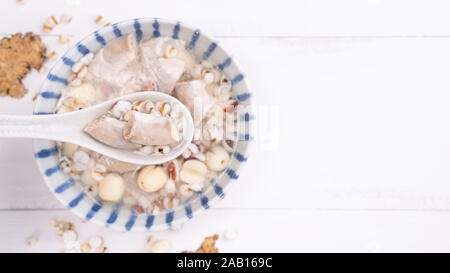 Lecker vier Stärkungsmittel Kraut Geschmack Suppe, Taiwanesische traditionelle Speisen mit Kräutern, schweinedickdarm auf weissem Holztisch, Nahaufnahme, Flach, Ansicht von oben. Stockfoto