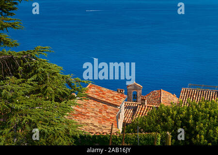 Aus Terrakotta Dächer von das Dorf Eze kontrastieren mit dem tiefen Blau des Mittelmeers. Côte d'Azur, Alpes-Maritimes (06), Frankreich Stockfoto