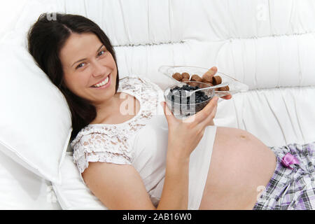 Foto der schwangeren Frau mit Heidelbeeren und Schokolade Stockfoto