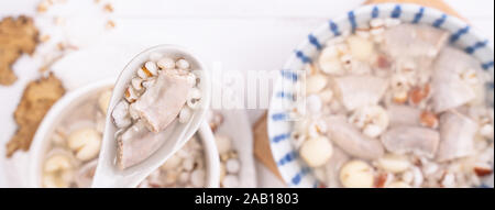 Lecker vier Stärkungsmittel Kraut Geschmack Suppe, Taiwanesische traditionelle Speisen mit Kräutern, schweinedickdarm auf weissem Holztisch, Nahaufnahme, Flach, Ansicht von oben. Stockfoto