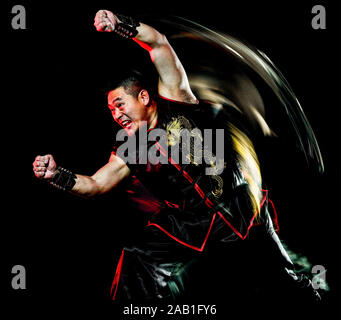 Wushu chinesisch Boxing Hung Gar Kung Fu Fighter isolierte Mann auf schwarzen Hintergrund mit Geschwindigkeit Licht Malerei Wirkung Bewegungsunschärfe isoliert Stockfoto