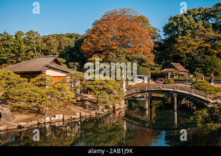 18.November 2014 Okayama, Japan - Alte vintage japanisches Teehaus in Okayama Korakuen park mit Holzbrücke und Teich im Herbst Saison Stockfoto