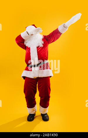 Happy dancing Santa Claus squating und winkende Hände Stockfoto