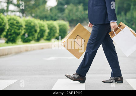 Zugeschnittenes Bild des Menschen, die Einkaufen - Taschen mit Paketen, die er zum Verkauf gemacht Stockfoto