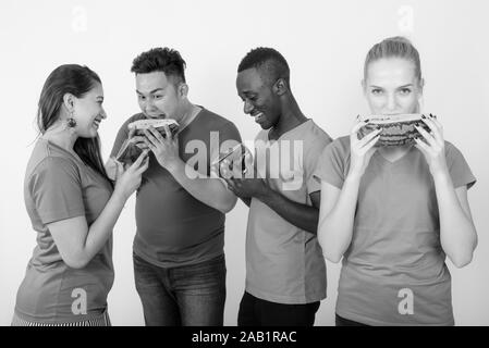 Happy teenage Mädchen mit vielfältigen Gruppe von multi-ethnische Freunde im wieder ein Lächeln beim Essen ein Stück Wassermelone zusammen Stockfoto