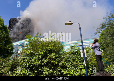 Zuschauer beobachten die Grenfell Turm Feuer. Grenfell Tower ist ein 24-stöckiges Mehrfamilienhaus Teil der Lancaster West Estate, ein Rat Wohnanlage Stockfoto