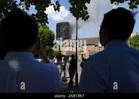 Zuschauer beobachten die Grenfell Turm Feuer. Grenfell Tower ist ein 24-stöckiges Mehrfamilienhaus Teil der Lancaster West Estate, ein Rat Gehäuse Ergänzungen Stockfoto