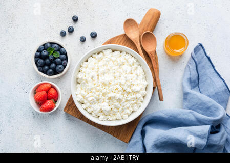 Quark in der Schüssel. Hausgemachte Topfen serviert mit frischen Beeren Blueberry Erdbeer- und Honig. Fermentierte Milchprodukte, die reich an Protein, Gesundheit Stockfoto