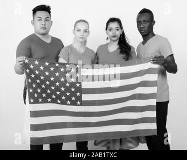 Studio Aufnahme der vielfältigen Gruppe von multi-ethnische Freunde halten Sie die amerikanische Flagge zusammen Stockfoto