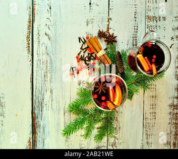 Warme Weihnachten Zusammensetzung, zwei Gläsern Glühwein mit Früchten und Gewürzen, durch Tannen Zapfen und Zweigen umgeben. Close-up. Stockfoto