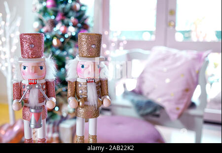 Im trend Rosa und Rose Gold Getrimmt Weihnachtsbaum mit Fach von Cookies und heiße Schokolade für Santa, schließen auf Nussknacker. Stockfoto