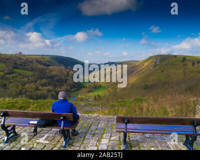 Mann sitzt auf der Bank an viewpoin über Monsal Dale & Monsal Kopf (Grabstein) in der Nähe von Bakewell in der Peak District National Park, Derbyshir Stockfoto