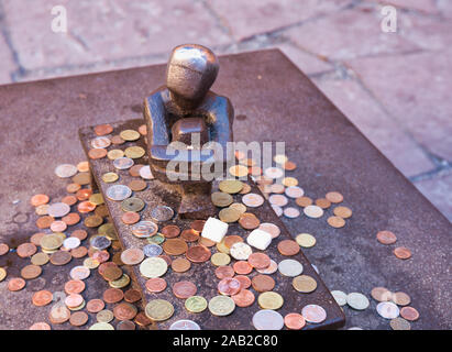 Winzige Jarnpojke oder Eisen Junge Skulptur von Münzen durch Touristen umgeben, Gamla Stan, Stockholm, Schweden Stockfoto