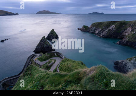 Frau und Kind bergauf an windigen Straße nach Dunquin Hafen, in Dunquin, County Kerry, Republik von Irland Stockfoto