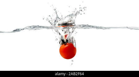 Nahaufnahme von frischen und gesunden Tomaten, die in klares Wasser fallen und großen Spritzer haben Stockfoto