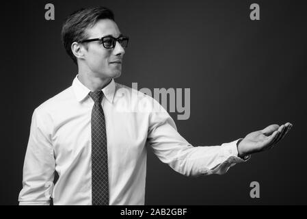 Junge gut aussehender Geschäftsmann mit Brillen in Schwarz und Weiß Stockfoto