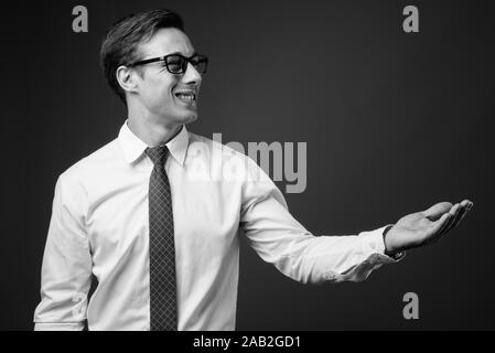 Junge gut aussehender Geschäftsmann mit Brillen in Schwarz und Weiß Stockfoto