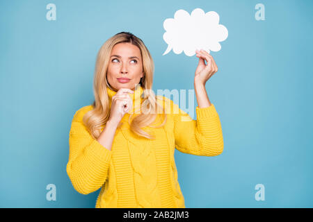 Foto von erstaunlichen blonde Frau Papier verstand Cloud denken über kreativen Dialog Antwort Hand am Kinn Verschleiß gestrickt gelb Pullover isoliert Blau Stockfoto