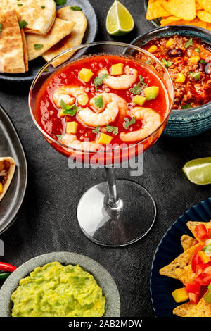 Mexikanisches Essen, viele Gerichte der Küche von Mexiko auf einem schwarzen Hintergrund. Krabbencocktail, Chili con Carne, Quesadillas, Guacamole Stockfoto