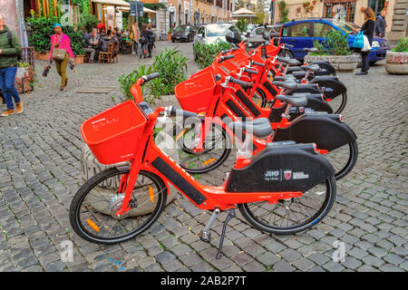 Rom, Italien Rot Uber Jump Pedal-assist Fahrräder geparkt. Dockless Elektrofahrrad sharing System rund mit Korb auf einem Bürgersteig in Trastevere. Stockfoto