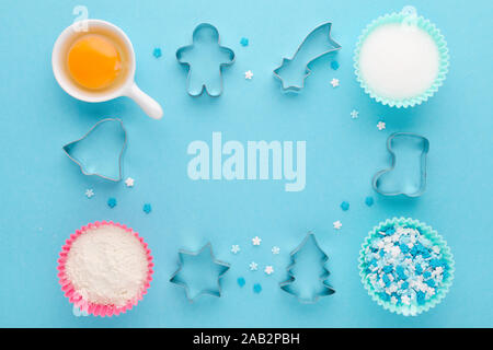 Backzutaten und Cookie Cutter auf blauem Hintergrund, flach Stockfoto