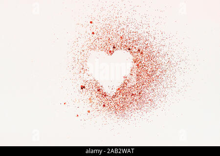 Herzform aus rotem Glitzer und Sterne auf einem weißen Hintergrund. Valentines Tag, minimale Liebe Konzept. Stockfoto