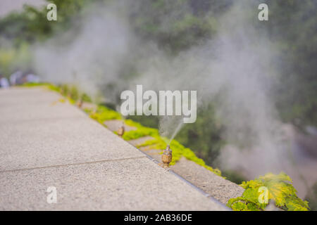 Das Bewässerungssystem close-up. Befeuchtung der Luft durch Dampf auf der Straße im Freien in einem heißen Sommer Tag morgen Stockfoto