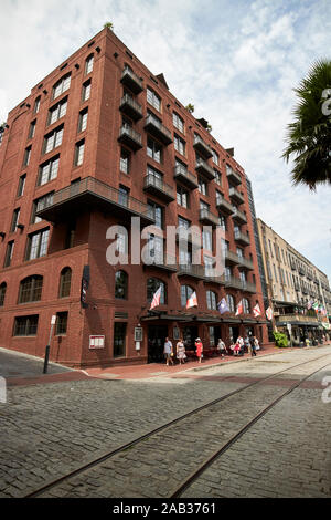 Böhmisches Hotel in alten Lagerhallen umfunktionierte entlang der Straße mit Straßenbahn Schienen in gepflasterten Straße Savannah Georgia USA Stockfoto