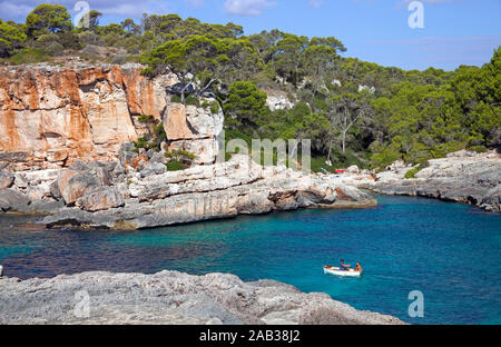 Ruderboot an der felsigen Küste von Cala S'Almonia, Naturpark Cap de Ses Salines, Cala Llombards, Mallorca, Balearen, Spanien Stockfoto