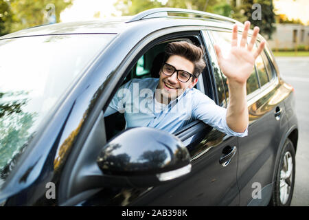 Selektiver Fokus der glücklichen Menschen fahren Auto und winkende Hand Stockfoto