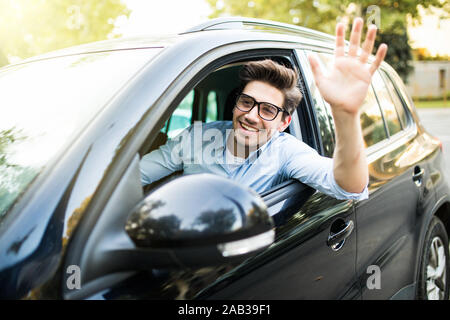 Selektiver Fokus der glücklichen Menschen fahren Auto und winkende Hand Stockfoto